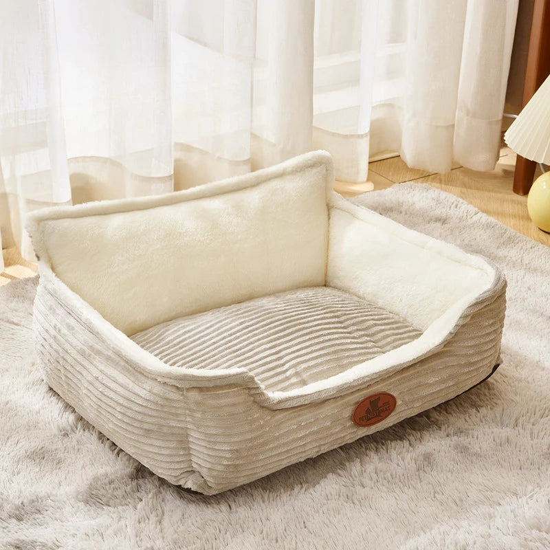 Plush rectangular dog bed with raised sides on a soft rug in a sunlit room