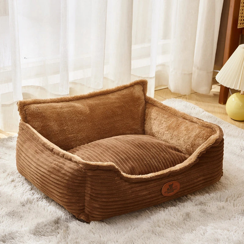 Plush brown corduroy dog bed with high sides on a soft rug in a cozy room setting
