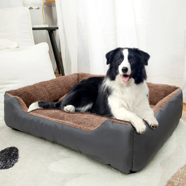 Black and white dog resting in a large, plush, rectangular calming dog bed indoors