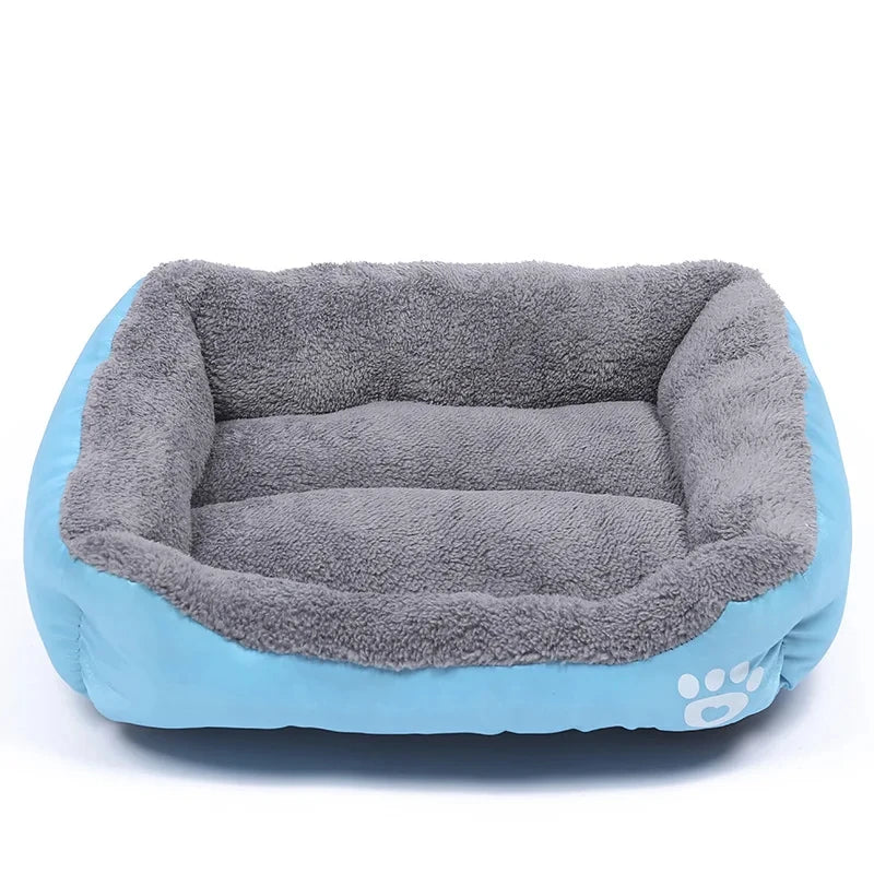 Plush gray and blue rectangular dog bed with soft raised edges and paw print detail
